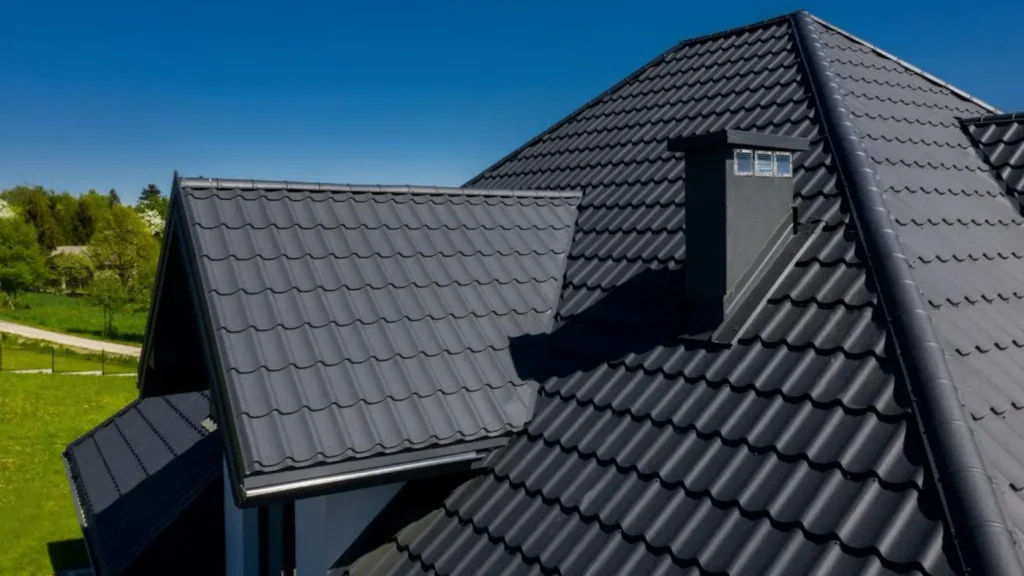 Maison avec toiture en bac acier imitation tuile gris ardoise posée sur charpente traditionnelle